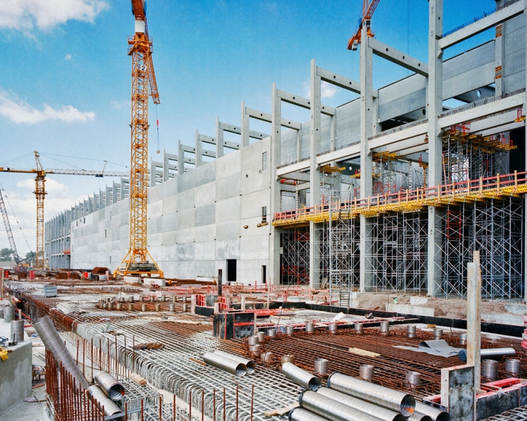 Baustelle eines großen Immobilienprojektes mit Kränen und Bauteilen