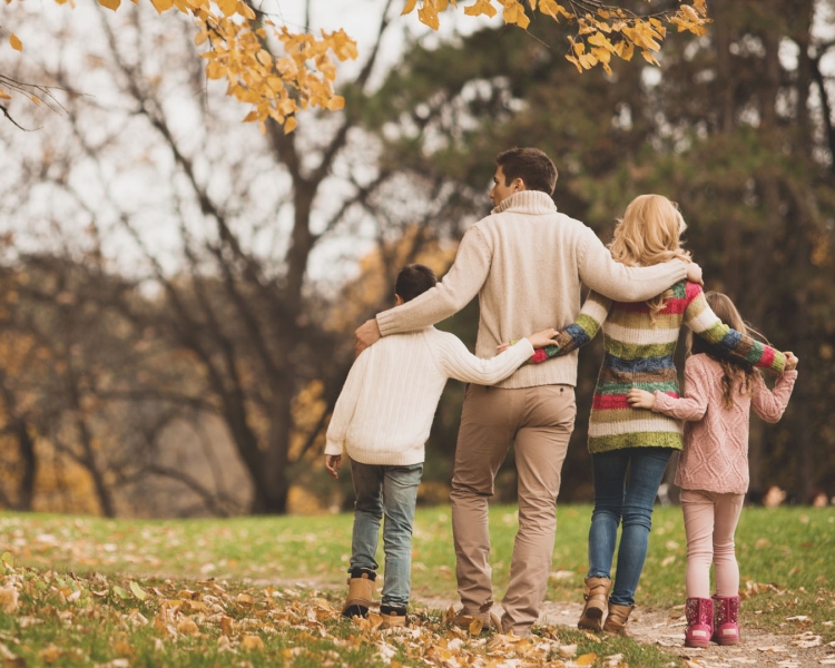 A family takes a walk in autumn in a park