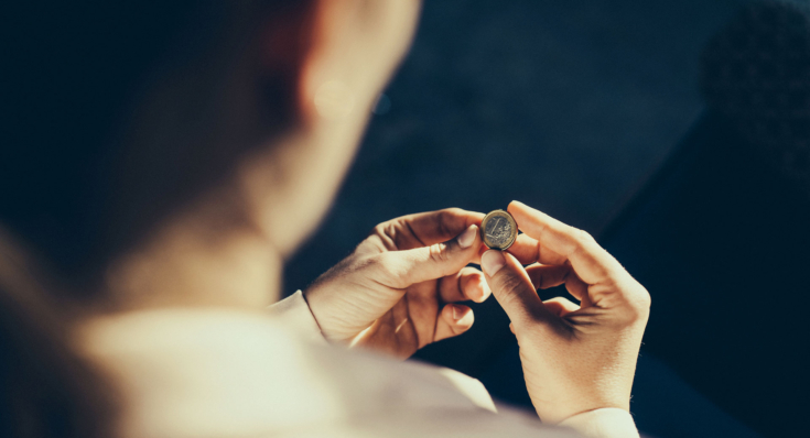 Eine Frau betrachtet eine Münze