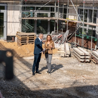 2 Personen stehen auf einer Baustelle und besprechen etwas