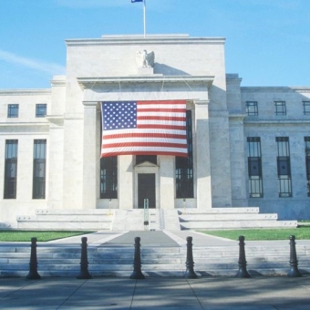 Gebäude mit der USA Flagge im Vordergrund.