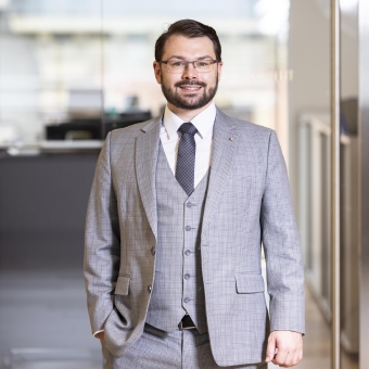 Ein Mann mit einer Brille in einem grauen Anzug