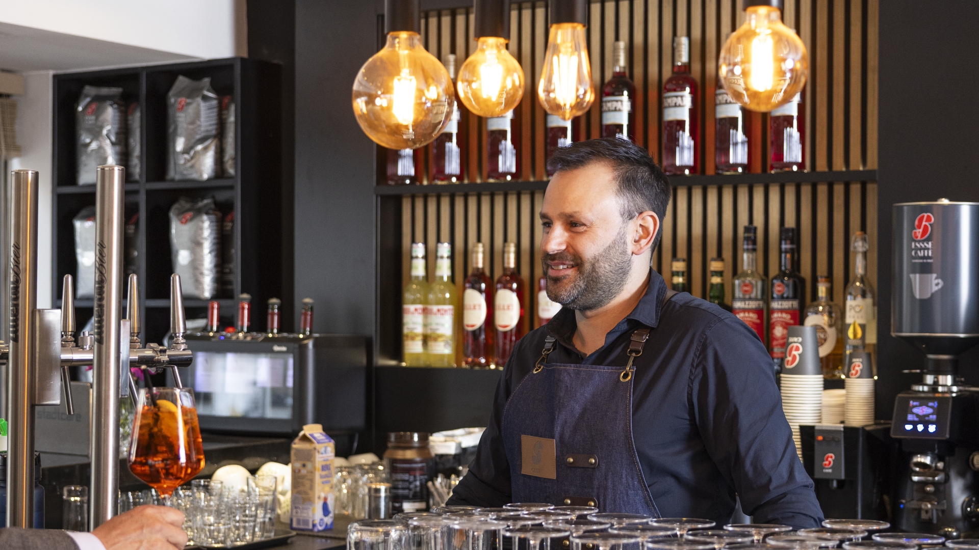 Ein Mann lächelt hinter einer Bartheke