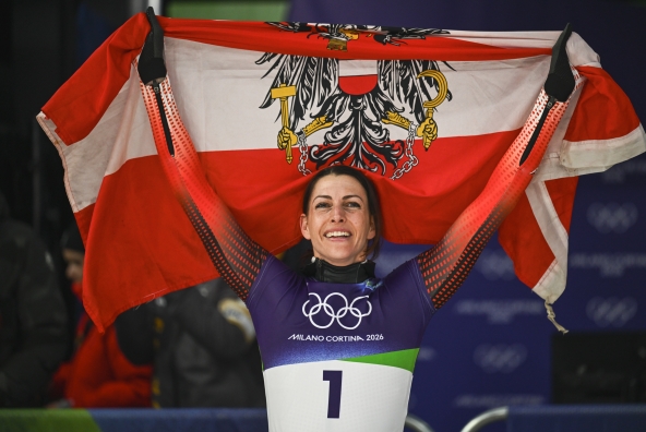 Janine Flock hält die Flagge von Österreich in den Händen und feiert ihren Olympiasieg