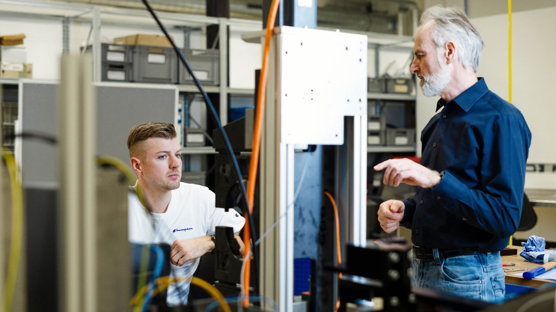 Zwei Mitarbeiter der HENN Connector Group diskutieren in einer Montagehalle.