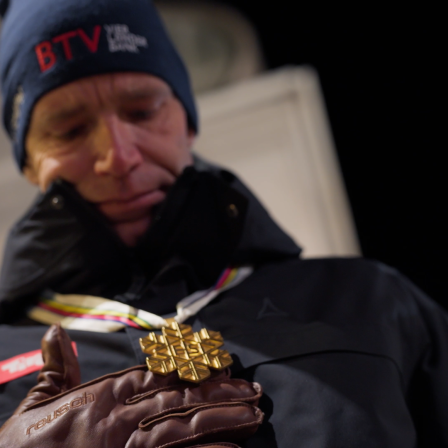 Skilegende Benni Raich blickt auf die goldene Medaille, die er in Bormio gewonnen hat.