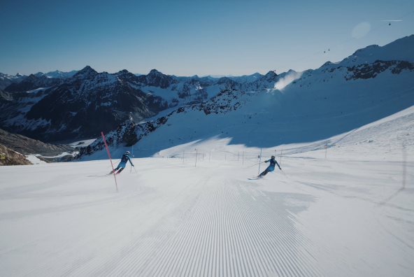 Marlies und Benni Raich fahren gemeinsam einen Skihang in den Alpen hinunter.