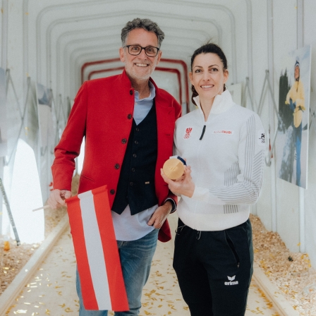 Skeletonpilotin Janine Flock und der BTV‑Vorstandsvorsitzende posieren vor der Kamera, nachdem Flock bei den Winterspielen 2026 die Goldmedaille gewonnen hat.