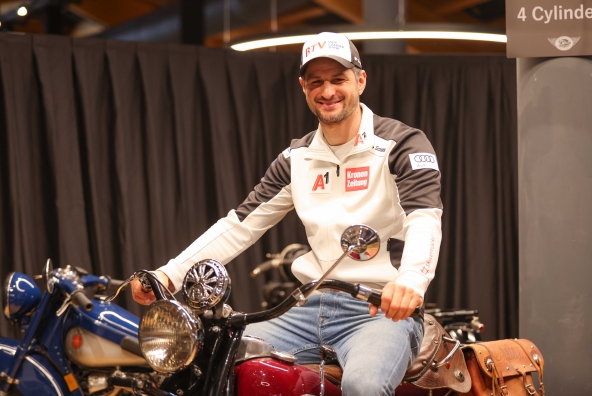 Skirennläufer Johannes Strolz sitzt auf einem klassischem Motorrad.