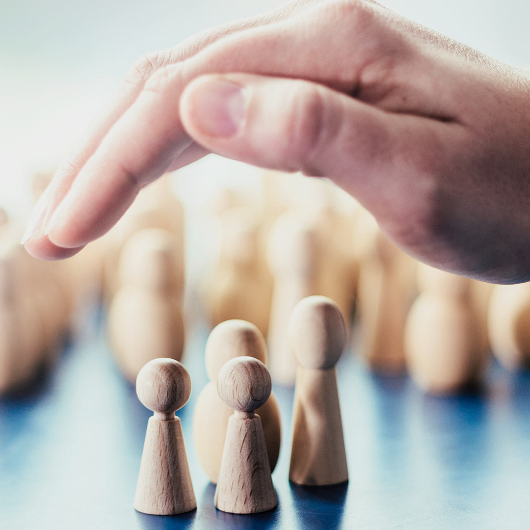 A person holds one hand over chess pieces