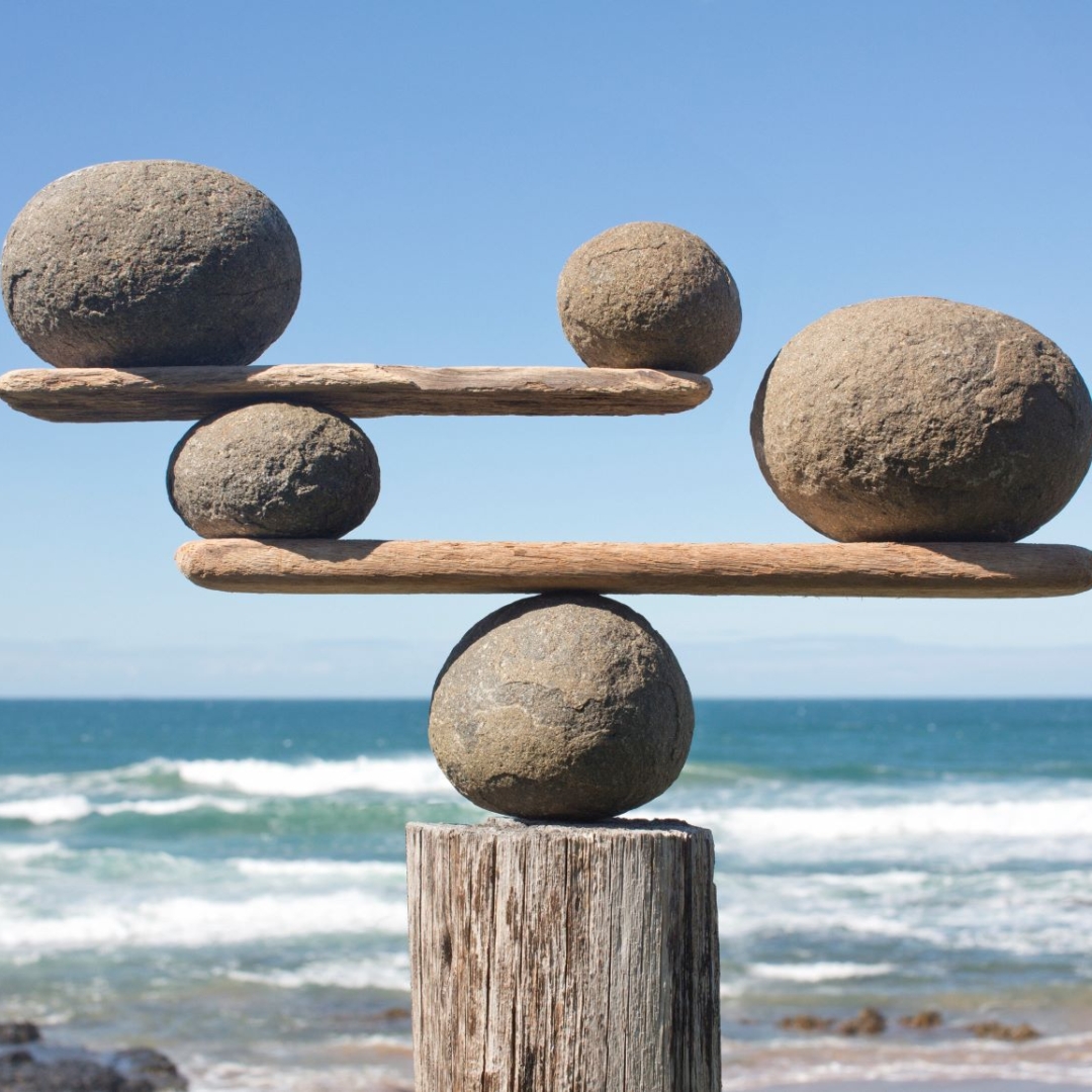 Ein Kunstwerk aus Holz und Steinen auf einem Strand