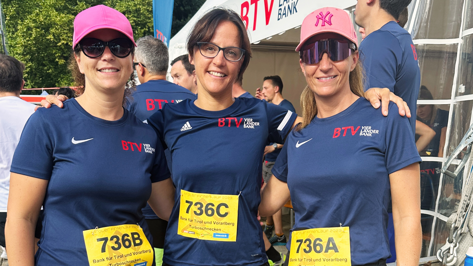 Drei BTV Mitarbeiterinnen in blauen Laufshirts beim Tiroler Firmenlauf
